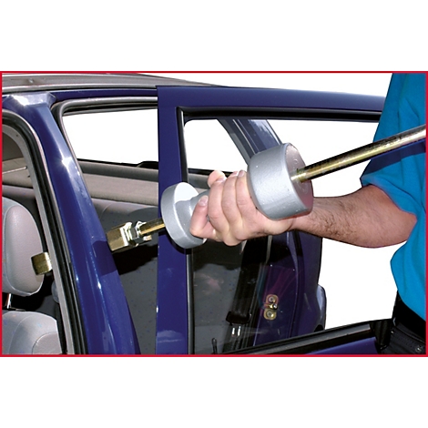 Person repariert Auto. Er verwendet ein Werkzeug an der Autotür.